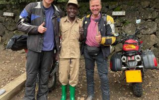 Zwei Motorradfahrer mit Einheimischen in Afrika